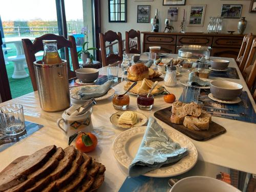 - une table avec du pain et d'autres aliments dans l'établissement La Bretonniere, à Dragey-Ronthon