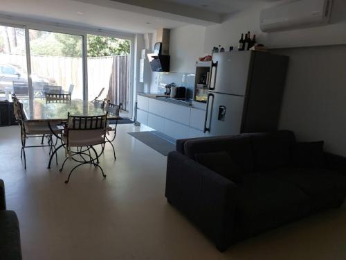 - un salon avec un réfrigérateur, une table et des chaises dans l'établissement le logis du truqué, à Lège-Cap-Ferret