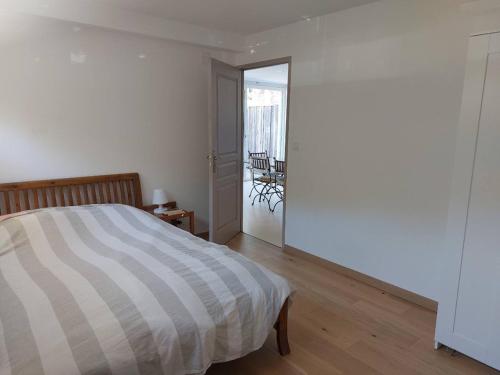 - une chambre avec un lit et une porte donnant sur un balcon dans l'établissement le logis du truqué, à Lège-Cap-Ferret