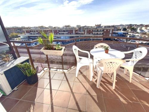 un patio con dos mesas y sillas en un balcón en CUNIT PLaYA, en Cunit