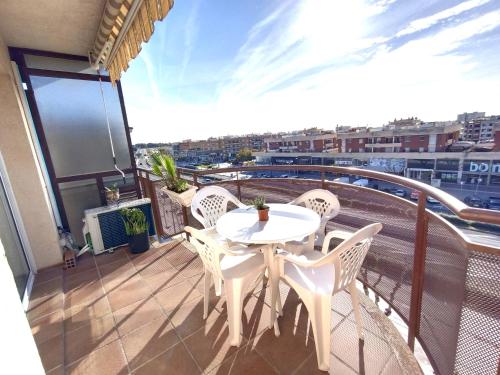 Un balcón con una mesa y sillas blancas. en CUNIT PLaYA, en Cunit