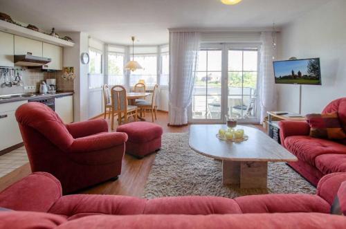 a living room with red couches and a table at FeWo Krüger 19 in Dahme