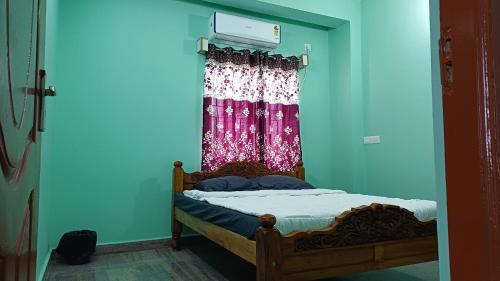 a bedroom with a bed and a window with a curtain at WHITRS INN KILAMBAKKAm in Chennai