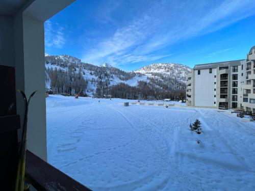 - une vue sur un parking couvert de neige en face d'un bâtiment dans l'établissement Isola 2000 - Front neige Galerie marchande, à Isola 2000