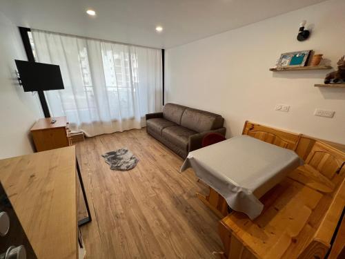 un salon avec un canapé et une table dans l'établissement Isola 2000 - Front neige Galerie marchande, à Isola 2000