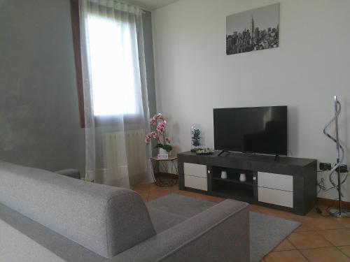 a living room with a couch and a flat screen tv at Appartamenti Euganea - Rovolon in Rovolon