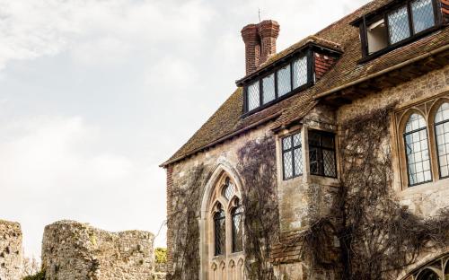 an old stone building with windows and a chimney at Amberley Castle- A Relais & Chateaux Hotel in Amberley