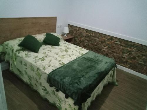 a bedroom with a bed with green sheets and green pillows at Apartamento Casa Vega in Bueu