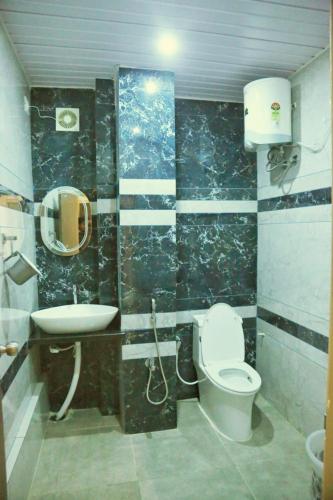 a bathroom with a toilet and a sink at Hotel Greenland in Khammam