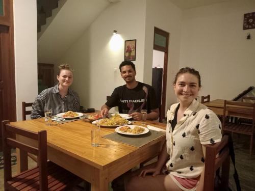 three people sitting at a table with plates of food at Yala wind in Tissamaharama