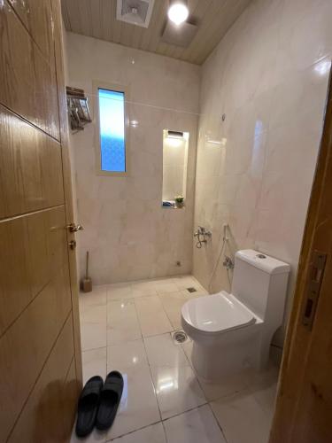 a white bathroom with a toilet and a shower at كوخ الوهط الريفي in Taif