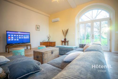 un salon avec des canapés et une télévision à écran plat dans l'établissement Le Florentin - Spacious Family Home in a Peaceful Village near Limoges, à Condat-sur-Vienne