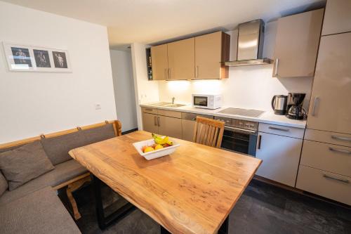 Una cocina con una mesa de madera con un bol de fruta encima. en Fewo Schwarzwaldstern 1, Todtnau, 3 Schlafzimmer, en Todtnau