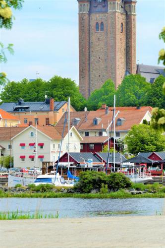 a town with a clock tower and a marina with boats at Vänerport Lakefront Hotell in Mariestad