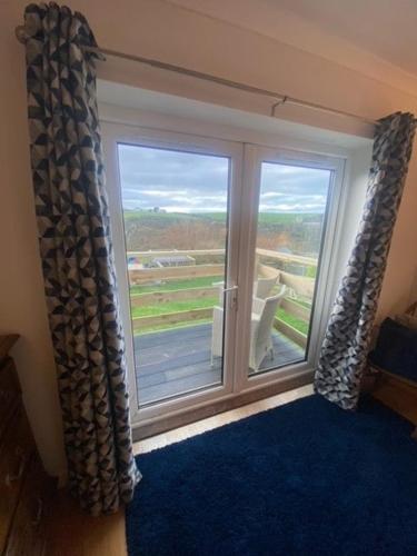 a room with a large window with a view at Valley View in Port Isaac