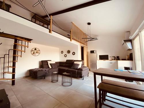un salon avec un canapé et une table dans l'établissement Petite maison avec accès piscine et jacuzzi chauffée, à Istres