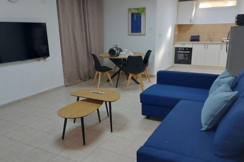 a living room with a blue couch and a table at דירת נופש in Ramat Yishay