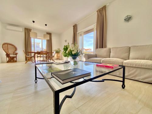 a living room with a glass table and a couch at Maison Sciscì in San Felice Circeo