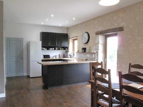 Il comprend une cuisine équipée d'un réfrigérateur blanc, d'une table et de chaises. dans l'établissement La Bergerie, à Pessac-sur-Dordogne