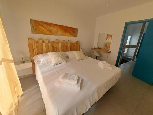 a bedroom with a large white bed with towels on it at La Casita de Ana in Águilas