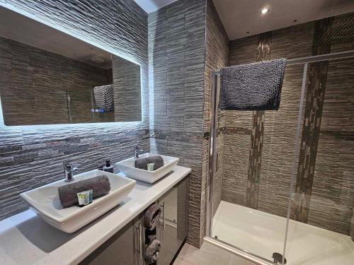 a bathroom with two sinks and a shower at The Manor in Bishop Auckland