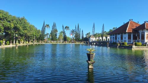 a fountain in the middle of a lake with a building at Frangipani Inn & Restaurant in Seraya