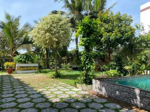 a resort with a swimming pool and a garden at Villa Nghỉ Dưỡng Nguyên Căn in Trung An