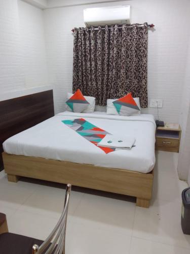 a bedroom with a large bed with a window at Gandharva Residency Koregaon Park in Pune