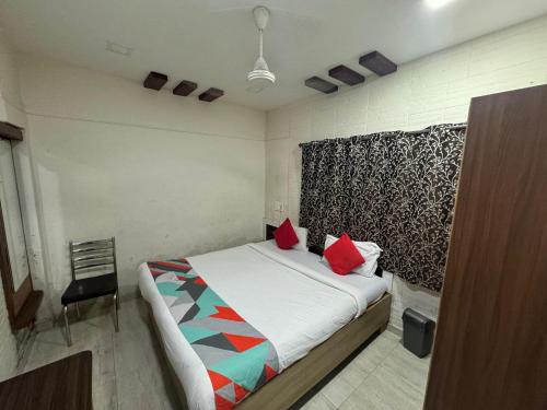 a bedroom with a bed with red pillows on it at Gandharva Residency Koregaon Park in Pune