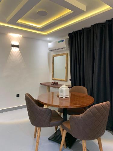a room with a table and chairs and a mirror at Accommodation Guru in Abuja
