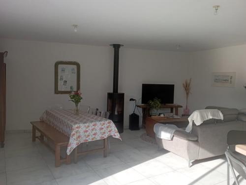 a living room with a couch and a tv at Chambre chez l'habitant in Le Val-Saint-Père