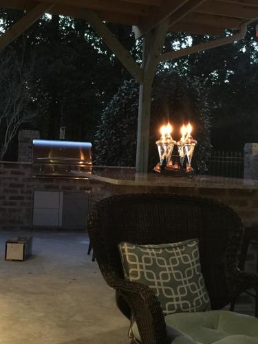a fire pit with a chair and a grill at Louisiana Cajun Mansion in Youngsville