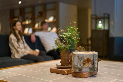 a table with two plants on it with a couple at Hotel Resol Nagoya in Nagoya