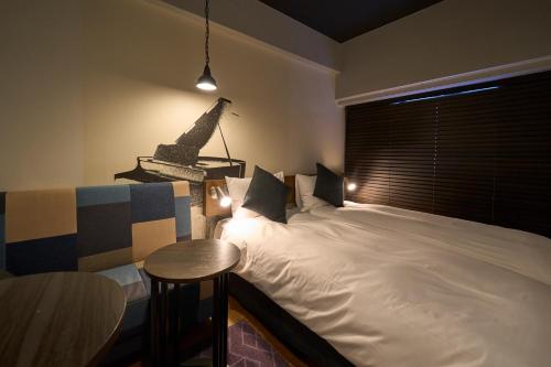 a bedroom with a large white bed and a table at Hotel Resol Nagoya in Nagoya