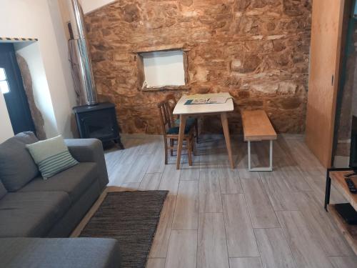 a living room with a table and a stone wall at Casa Hozani in Albarrol