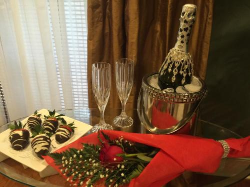 a glass table with a bottle of champagne and desserts at Louisiana Cajun Mansion in Youngsville