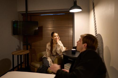 a man and a woman sitting at a table in a room at Hotel Resol Nagoya in Nagoya