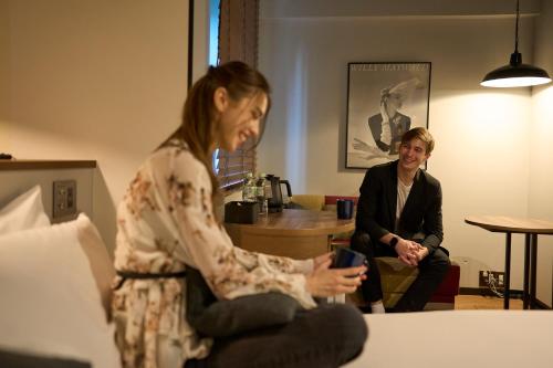 a man and a woman sitting in a room at Hotel Resol Nagoya in Nagoya