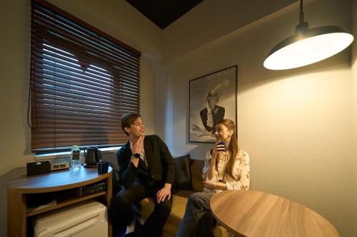 a man and a woman sitting on a couch with microphones at Hotel Resol Nagoya in Nagoya