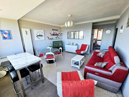 un salon avec un canapé rouge et une table dans l'établissement Appartement Banyuls sur Mer face à la mer, à Banyuls-sur-Mer