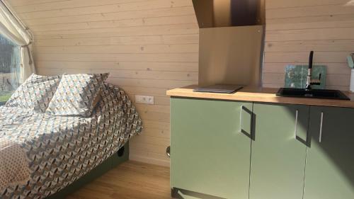 - une petite chambre avec un lit et un comptoir dans l'établissement Tiny luxe & Spa privatif - les Figuiers, à Barjou