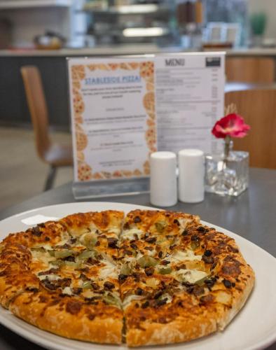 a pizza sitting on a plate on a table at Stableside Hostel at York Racecourse in York