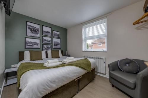 a bedroom with a large bed and a chair at Stableside Hostel at York Racecourse in York