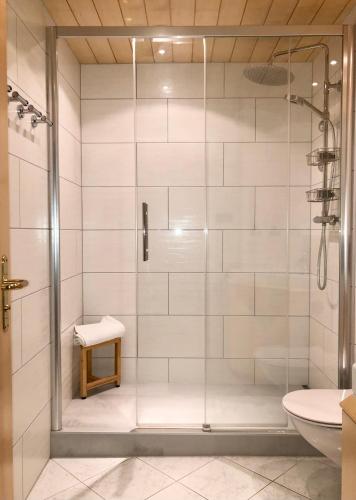 a shower with a glass door in a bathroom at Rancho Laaxdeluxe in Laax