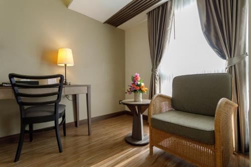 a room with a desk and a chair and a table at Amora Thapae Hotel Chiang Mai in Chiang Mai