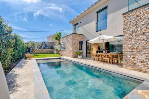 une piscine dans l'arrière-cour d'une maison dans l'établissement Villa Moderne avec Piscine Privée - Proche de Nice, à Carros