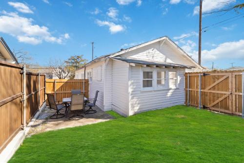 a backyard with a white house and a fence at Charming Bungalow in McKinney – Walk to Downtown bungalow in McKinney