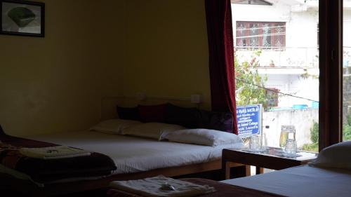 Postel nebo postele na pokoji v ubytování Satya Anand Cottage Pure Veg and Non Alcoholic Hotel