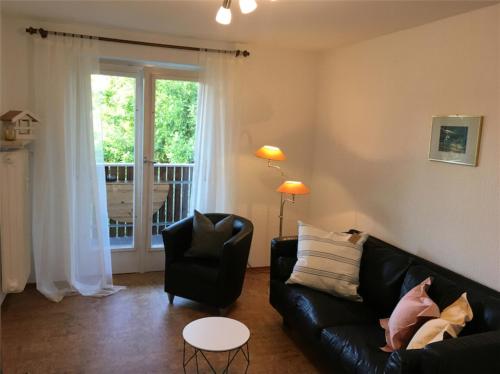 a living room with a couch and a chair and a window at Ferienwohnung Bluhm in Weilheim in Oberbayern
