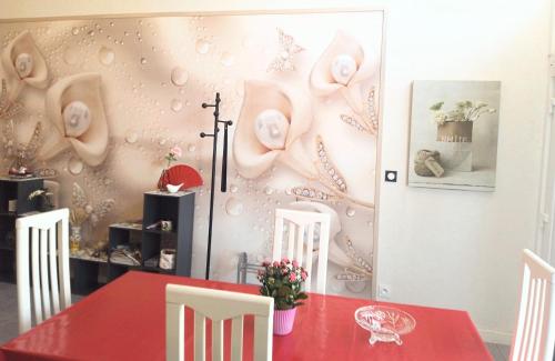 une salle à manger avec une table rouge et des chaises blanches dans l'établissement appartement T2 CHALOSSE, à Bahus-Soubiran